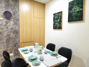 a dining room with a table with chairs and a clock at Kuching City Centre Smart Home Luxury Resort Condo in Kuching