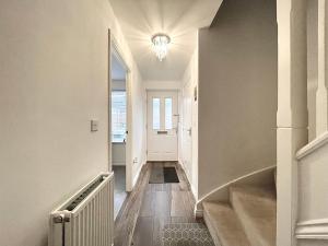 un couloir avec un escalier et une porte blanche dans l'établissement Genesis 3 bedroom Home Telford- sleeps up to 5, à Oakengates