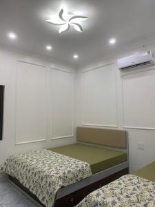 1 dormitorio con 2 camas y ventilador de techo en Rustic Homestay - Phòng nghỉ giá rẻ en Hai Phong