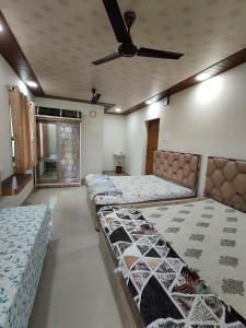 1 dormitorio con 3 camas y ventilador de techo en DR BHOIR FARM & RESORT, en Kalyan