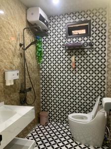 a bathroom with a toilet and a black and white tiles at Rustic Homestay - Phòng nghỉ giá rẻ in Hai Phong