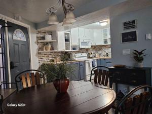 a kitchen with a wooden table with chairs and a dining room at Under the Dome in Pocatello