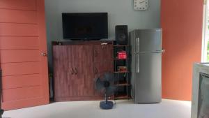 a room with a refrigerator and a tv and a fan at QuiapoSuites Bohol in Tagbilaran City