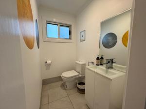 a bathroom with a toilet and a sink and a window at No 34 Where Nature Meets the Ocean Pet Friendly in Robe +10 photos