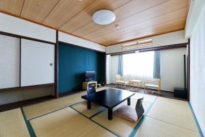 a living room with a table and a couch at Grand Mercure Minamiboso Resort & Spa in Minamiboso