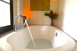 a large white bath tub with a faucet in a bathroom at Namkhan View Luangprabang Resort in Luang Prabang