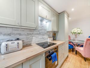 a kitchen with white cabinets and a counter top at Buttercup Cottage - Uk45969 in Yarm
