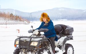 une femme assise sur une moto dans la neige dans l'établissement Rixos Borovoe, à Borovoe