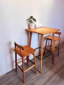 una mesa de madera y una silla con una planta. en Casa de Jumbo en Anping