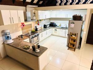 a large kitchen with white cabinets and a refrigerator at Seven Star Lodge in Port Vila