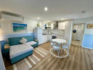 ein Wohnzimmer mit einem blauen Sofa und einem Tisch in der Unterkunft Driftwood - Bunbury in Bunbury