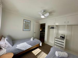 a bedroom with two beds and a ceiling fan at Driftwood - Bunbury in Bunbury