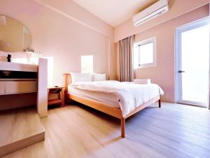 a hotel room with a bed and a mirror at Casa de Jumbo in Anping