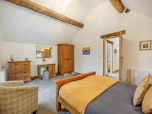 1 dormitorio con cama, silla y vestidor en Babbling Brook Barn en Abbots Bromley