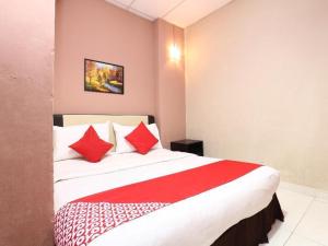 a bedroom with a large bed with red pillows at Destiny Riverside Hotel in Kota Bharu