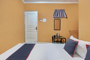 een slaapkamer met een bed en een deur bij Collection O 92864 Mitra Residence in Semarang