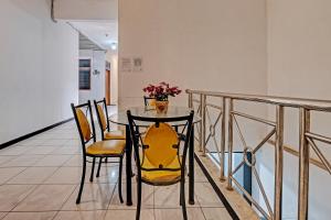 une table à manger avec des chaises et un vase de fleurs dans l'établissement Collection O 92864 Mitra Residence, à Semarang