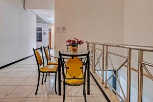 a dining room table with chairs and a vase of flowers at Collection O 92864 Mitra Residence in Semarang