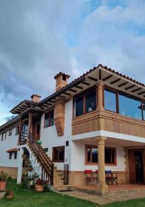 une grande maison blanche avec un toit en gambrel dans l'établissement El Bosque de la Villa Loft, à Villa de Leyva