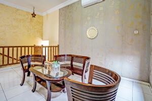 - une salle à manger avec une table et des chaises dans l'établissement OYO Life 92030 Ef Palm Guest House Family, à Surabaya