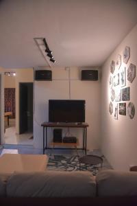 a living room with a couch and a tv on a wall at The Karaoke Homes Ipoh, Oldtown in Ipoh