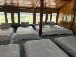a row of beds in a room with windows at Ly House in Sa Pa