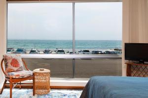 a bedroom with a large window with a view of the ocean at El Sandi 1 in Forster