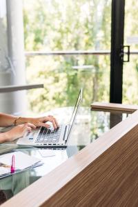 a person sitting at a table with a laptop computer at Crowne Plaza Canberra, an IHG Hotel in Canberra