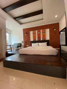 een slaapkamer met een groot bed met een bakstenen muur bij เดอะวิลล่า71 รีสอร์ท in Ban Zong Katiam