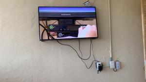 a tv hanging on a wall with a video game at Casa Mediterraneo in Chamela