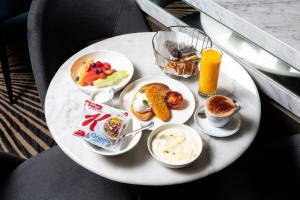 a white plate of breakfast food on a table at Crowne Plaza Canberra, an IHG Hotel in Canberra
