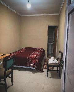 a bedroom with a bed and a desk and a table at HOSPEDAJE LA NORMA in Paso de los Libres