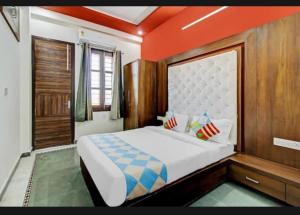 1 dormitorio con 1 cama grande y techo naranja en 7horses holidays homes, en Udaipur