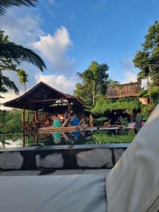 a group of people sitting under a pavilion at a resort at Tetebatu Sama Sama Bungalows in Tetebatu