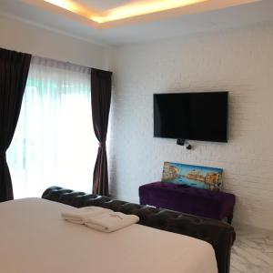 1 dormitorio con 1 cama y TV de pantalla plana en เดอะวิลล่า71 รีสอร์ท, en Ban Zong Katiam