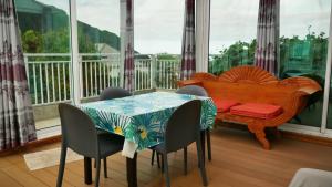 a dining room with a table and chairs and a bench at L'Idolivier in La Plaine des Palmistes