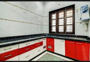 een keuken met rode en witte kasten en een raam bij 7horses holidays homes in Udaipur