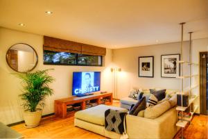 a living room with a couch and a tv at The SunCatcher in Cape Town