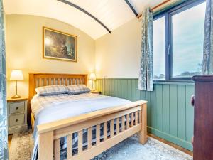 a bedroom with a bed and a window at The Brake Wagon in Halstead