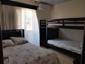 1 dormitorio con 2 literas y ventana en VILLA FAMILIAR Oasis Guacalillo, en Tarcoles