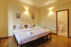 sypialnia z 2 łóżkami oraz łazienka z toaletą w obiekcie Genesis Leisure - Charming home-stays near Anjuna, Vagator & Assagao w mieście Anjuna
