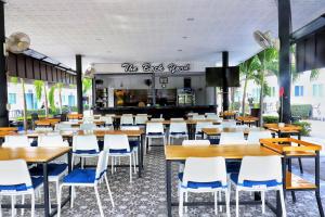 a restaurant with tables and chairs and a kitchen at Billabong Golf Club & Resort in Nong Prue