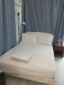 a large white bed with white sheets and pillows at Petit coin de paradis in Baie Nettle