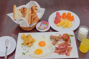 a table topped with plates of breakfast food with eggs at Lucky Angkor Hotel & Spa in Siem Reap