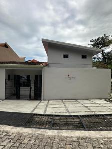 a white house with a garage in front of it at Casa Mariposa in Herradura