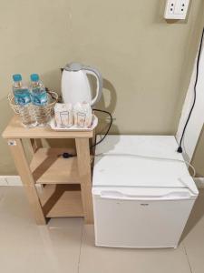 - Mesa pequeña con hervidor de agua y botellas de agua en Parida Resort, en Sing Buri