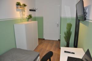 a room with a desk with a computer and a door at Hostel KarMa in Gelsenkirchen