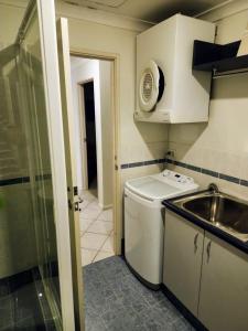 a small kitchen with a sink and a toilet at The Boardwalk Apartment in Rockingham