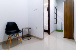 a black chair and a table in a room at Limo Depok Residence RedPartner in Depok +2 photos