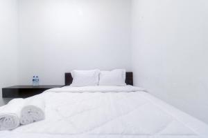 a white bed with white sheets and pillows at Limo Depok Residence RedPartner in Depok